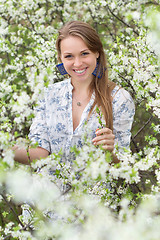 Image showing Smiling blonde in blooming garden