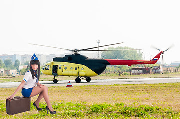 Image showing Beautiful air hostess in front of helicopter