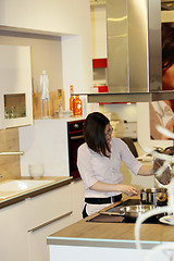 Image showing Young housewife cooking in a kitchen