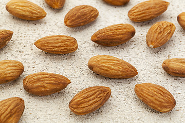 Image showing raw almonds on white wood