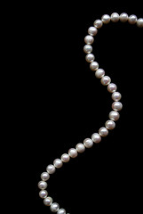 Image showing White pearls on the black silk as background 