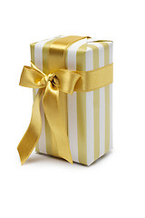 Image showing Gift box in gold duo tone with golden satin ribbon and bow isolated over white background.