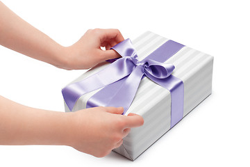 Image showing hand holding ribbon and open gift box