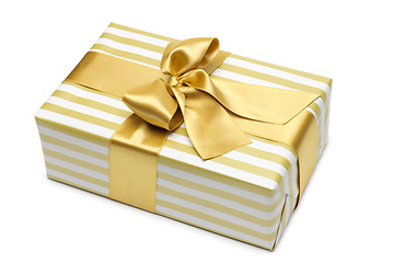 Image showing Gift box in gold duo tone with golden satin ribbon and bow isolated over white background.