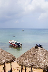 Image showing beach thatch roof restaurant huts with fishing boat Caribbean Se