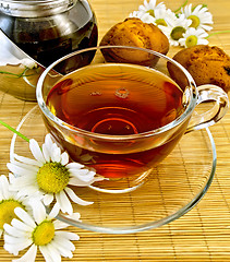 Image showing Herbal tea with daisies and kettle