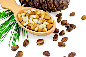 Image showing Nuts of cedar  in a wooden spoon and a bump