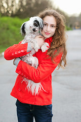 Image showing Brunette hugging little dog