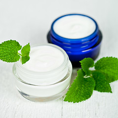 Image showing face cream in jars with urtica leaves