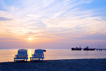 Image showing sunset on Picnic Center beach  lounge chairs and boats in distan