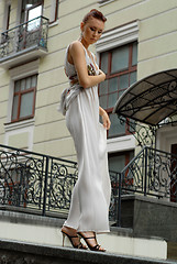 Image showing brunette in long dress near a hotel