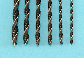 Image showing different size wood drill bits for wood on blue 