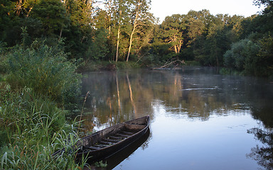 Image showing Beautiful river and old rowing boat in green grass