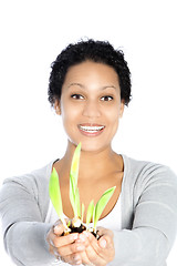 Image showing Young Afro-American woman holding a growing plant