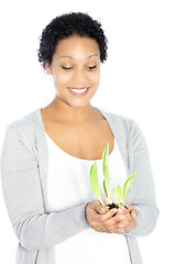 Image showing African American woman hollding a plant