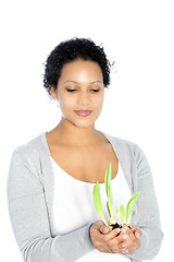 Image showing Afro-American young woman holding a plant