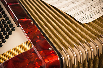 Image showing Red accordion and sheet music, close up