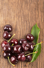Image showing Red, ripe, juicy cherries on wooden boards
