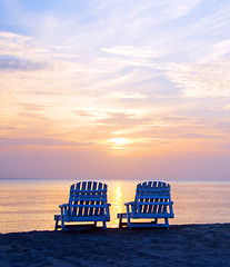 Image showing sunset on Picnic Center beach  lounge chairs and boats in distan