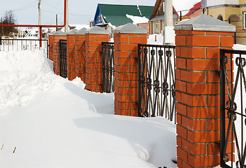 Image showing Red fence covered with snow