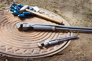 Image showing Hammer and wrench are on a manhole