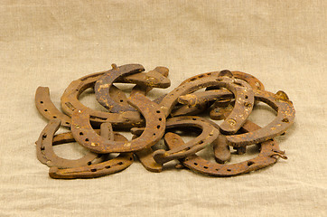Image showing stack old retro rusty horseshoes linen background 