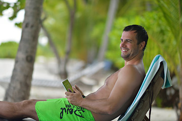 Image showing man ralaxing and use tablet at beach