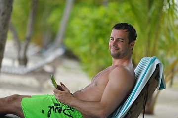 Image showing man ralaxing and use tablet at beach