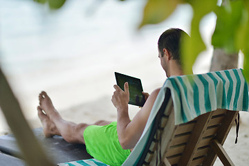 Image showing man ralaxing and use tablet at beach