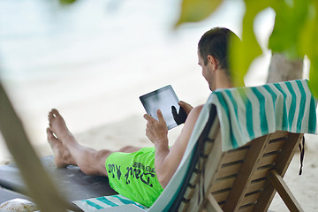 Image showing man ralaxing and use tablet at beach