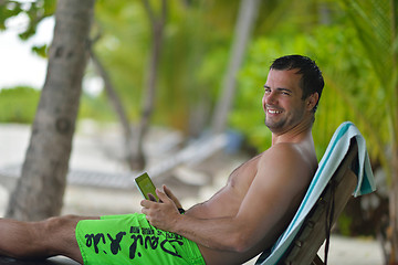 Image showing man ralaxing and use tablet at beach