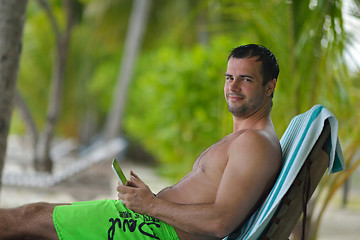 Image showing man ralaxing and use tablet at beach