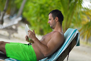 Image showing man ralaxing and use tablet at beach