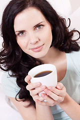 Image showing smiling brunette woman drinking black coffee