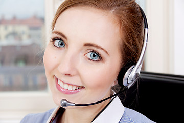 Image showing smiling young female callcenter agent with headset