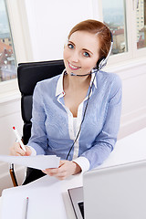 Image showing smiling young female callcenter agent with headset