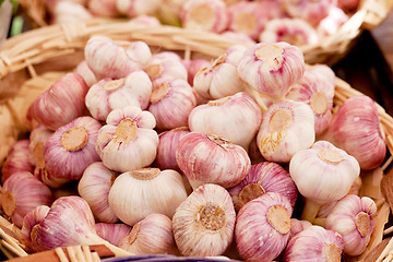 Image showing group of purple white garlic in basket macro