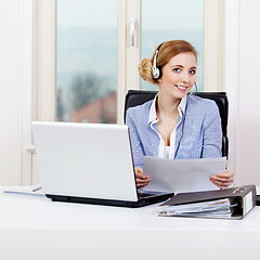 Image showing smiling young female callcenter agent with headset