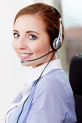 Image showing smiling young female callcenter agent with headset