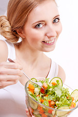 Image showing smiling woman eating fresh salad