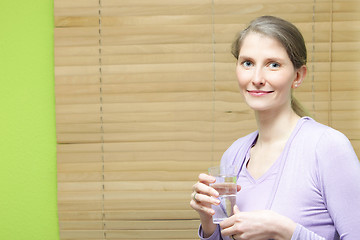 Image showing A young attractive woman holding a glass