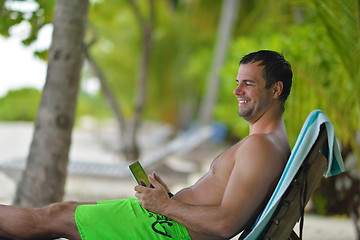 Image showing man ralaxing and use tablet at beach