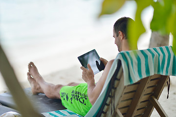 Image showing man ralaxing and use tablet at beach