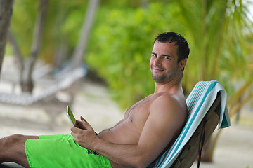 Image showing man ralaxing and use tablet at beach