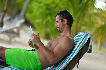 Image showing man ralaxing and use tablet at beach