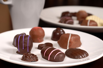 Image showing Close up of two plates of chocolates with a cup of hot chocolate
