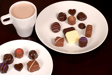 Image showing Top view of two plates of chocolates with a cup of hot chocolate