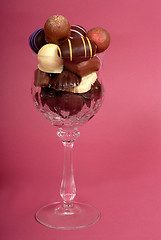 Image showing Delicious dark and semi-sweet chocolates in a cut crystal wine g