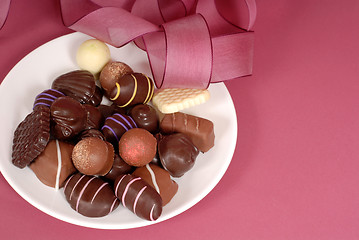 Image showing Plate of delicious dark and semi-sweet chocolates with pink ribb