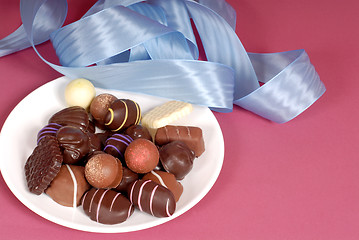 Image showing Plate of delicious dark and semi-sweet chocolates with blue ribb